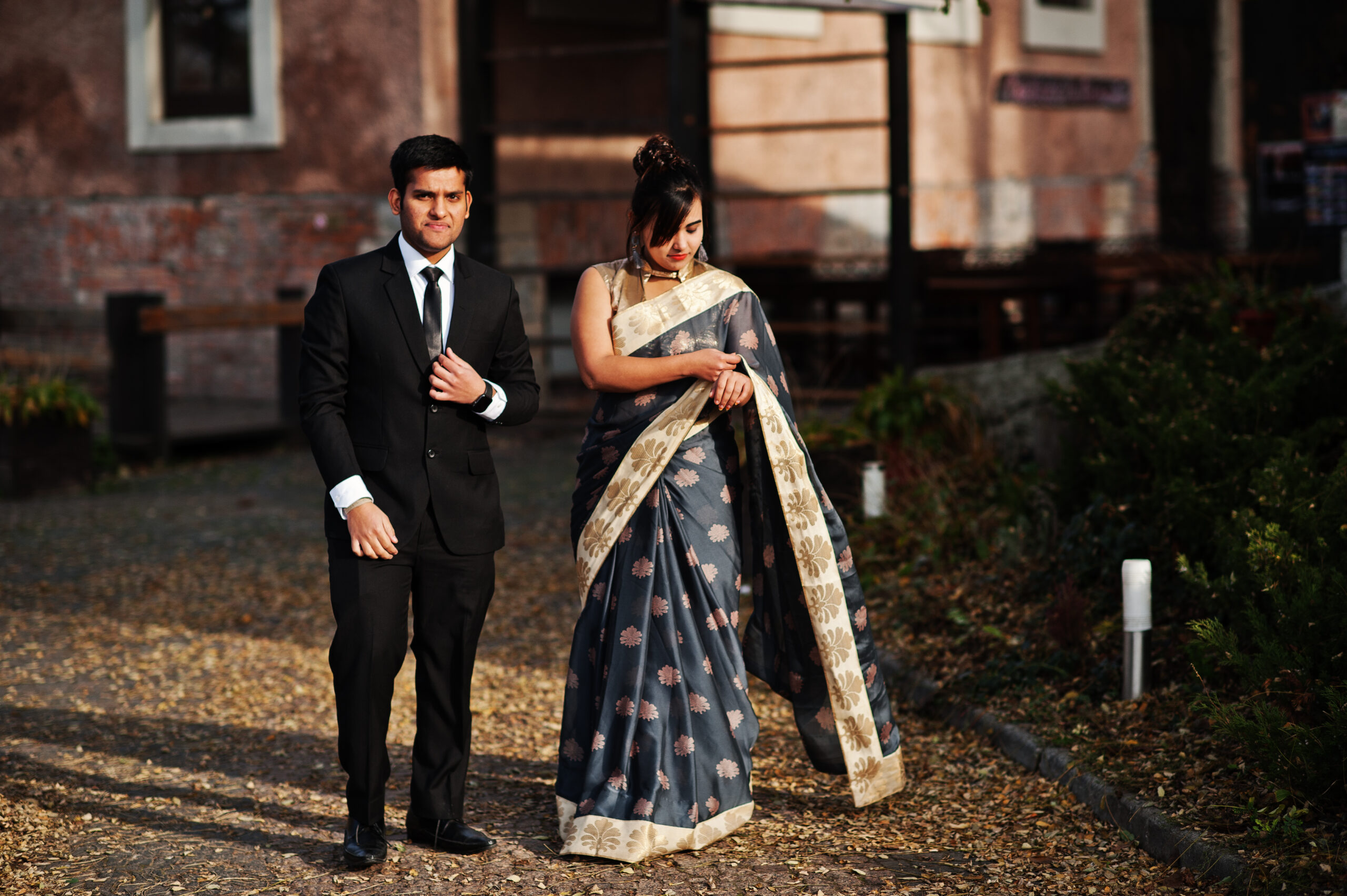 Elegant and fashionable indian friends couple of woman in saree and man in suit.