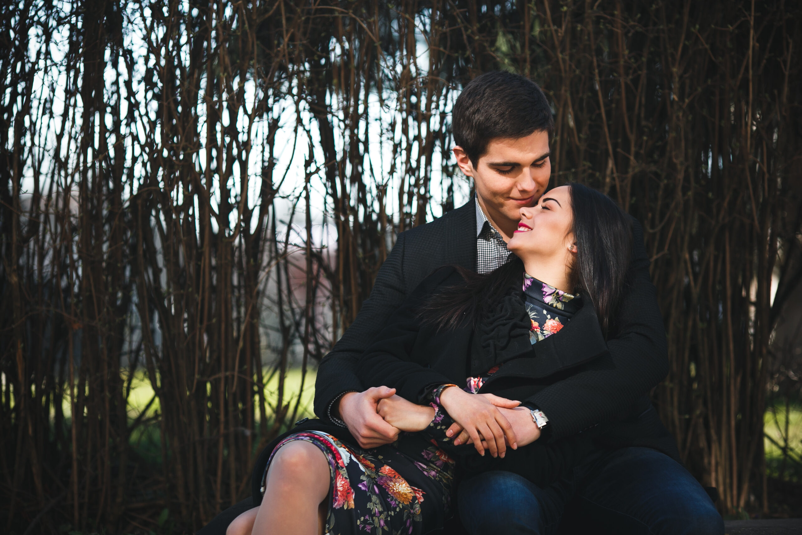 beautiful girl and her boyfriend resting together on a bench in the park